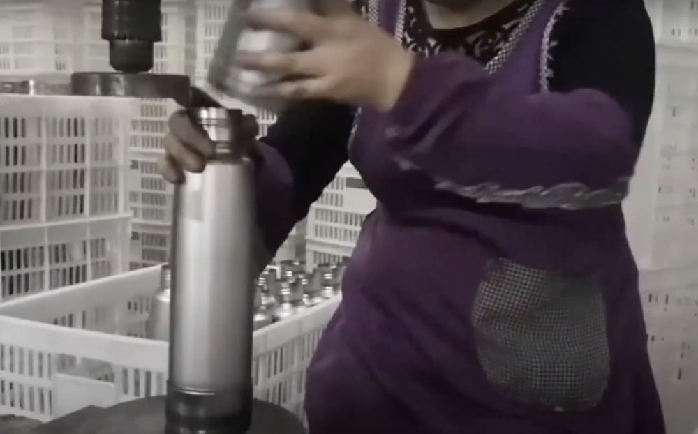 Close-up of the double-wall construction of an insulated bottle during the manufacturing process, highlighting the vacuum layer.